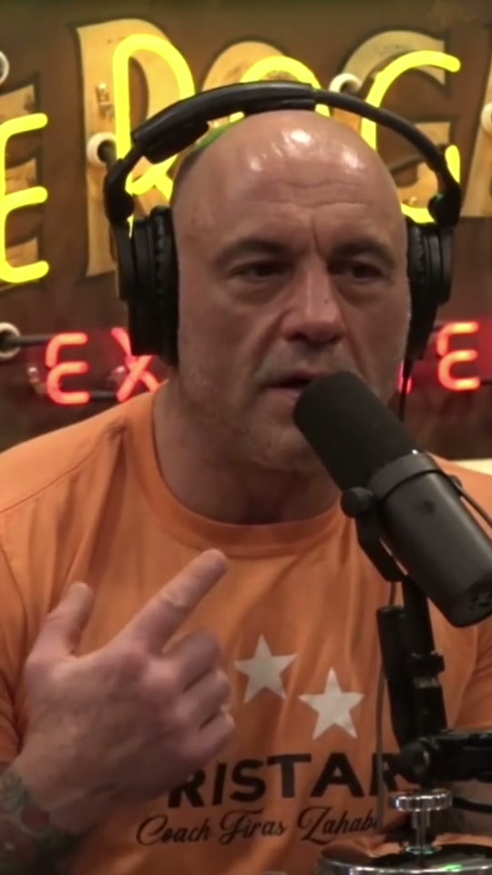 Podcast host in an orange shirt gesturing beside a microphone while explaining skill progression